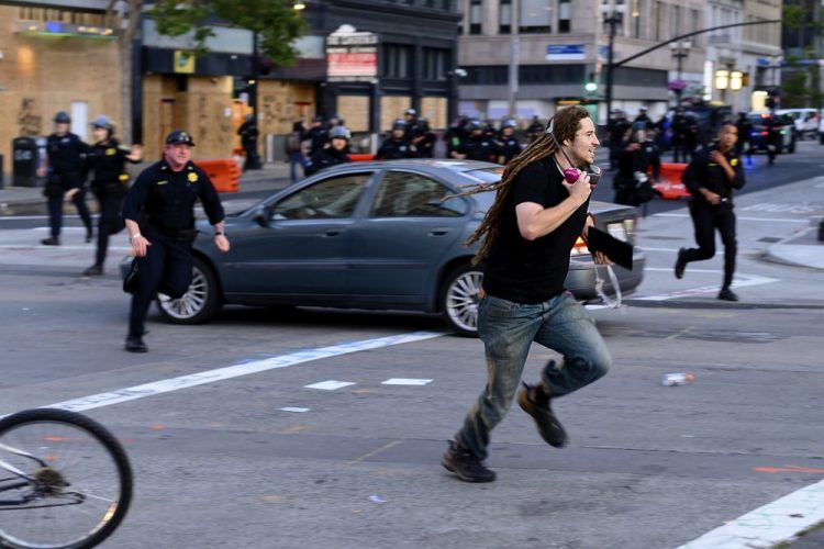 A man runs from police officers in Oakland, Calif., Monday, June 1.(