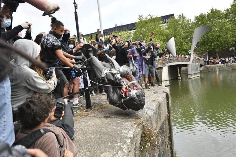Protesters throw a statue of slave trader Edward Colston into Bristol Harbour, during a Black Lives Matter rally, in Bristol, England, on Sunday, in response to the killing of George Floyd by police officers in Minneapolis. 