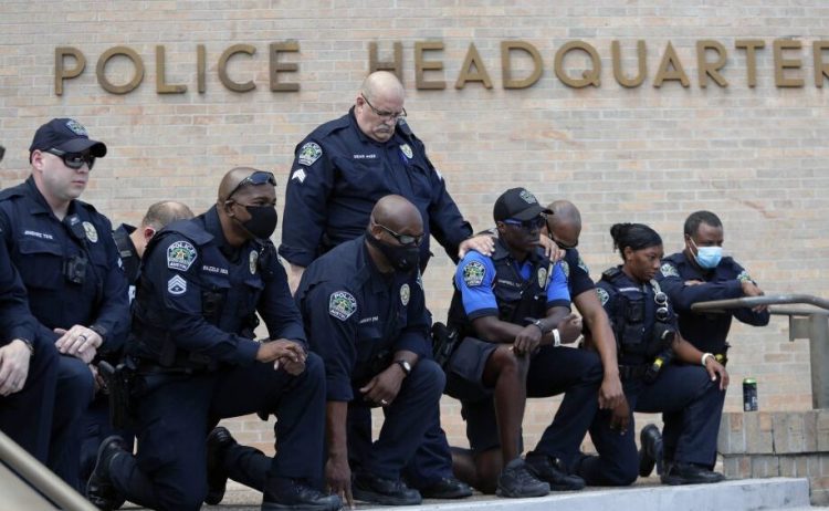 Members of the Austin Police Department kneel in front of demonstrators who gathered in Austin, Texas, on Saturday to protest the death of George Floyd, a black man who was in police custody in Minneapolis. Floyd's killing has prompted an extraordinary outcry for police reform, but will it lead to change?
