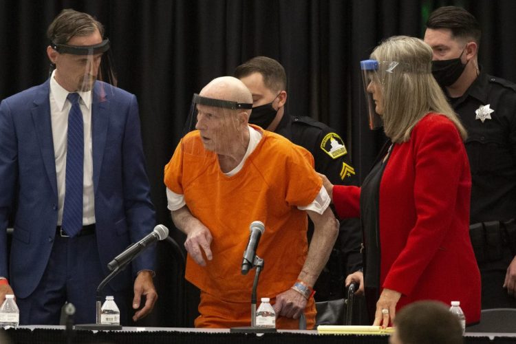 Joseph James DeAngelo Jr., center, charged with being the Golden State Killer, is helped up by his attorney, Diane Howard, as Sacramento Superior Court Judge Michael Bowman enters the courtroom in Sacramento, Calif., on Monday. DeAngelo pleaded guilty to multiple counts of murder and other charges 40 years after a sadistic series of assaults and slayings in California. 