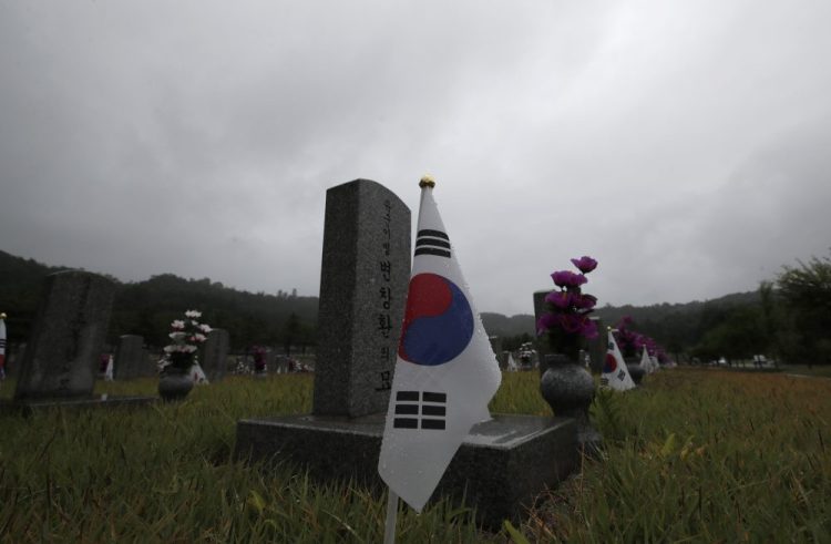 South Korean national flags are placed near the gravestones of soldiers who died during the 1950-1953 Korean War at the National Cemetery on Thursday in Seoul, South Korea. 