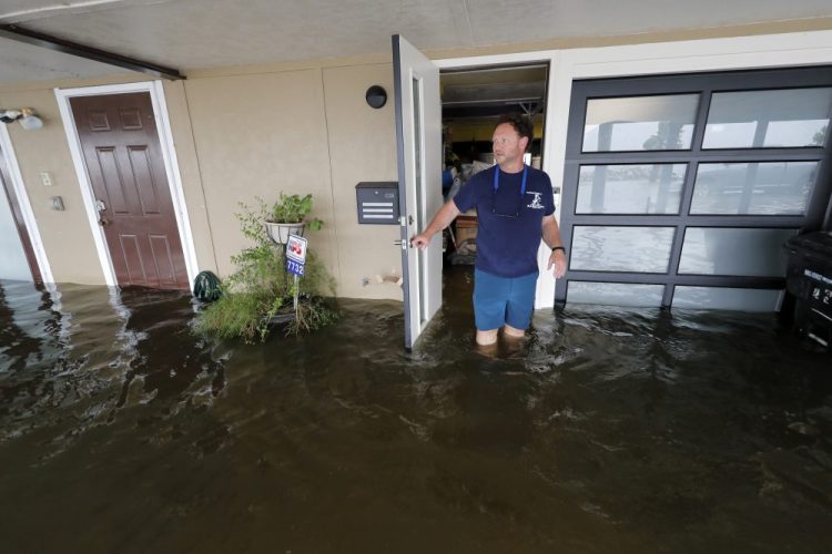 Rudy Horvath walks out of his home, a boathouse in the West End section of New Orleans, as it takes on water from a storm surge in Lake Pontchartrain in advance of Tropical Storm Cristobal on Sunday. 