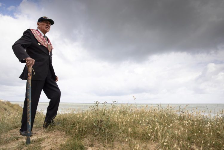 World War II D-Day veteran and Penobscot Elder from Maine, Charles Norman Shay poses on the dune overlooking Omaha Beach prior to a ceremony at his memorial on Friday.