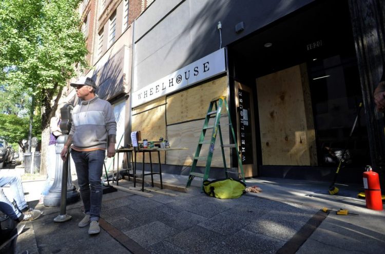 Johnny Grimes stands outside his salon Monday in Birmingham, Ala., as he boards up windows after it was vandalized and looted. Grimes said he was devastated by what had happened to his business but was sympathetic with those who demonstrated against police brutality.  