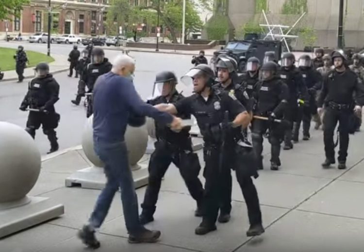 In this image from video, a Buffalo police officer appears to shove a man who walked up to police Thursday. The video shows the man appearing to hit his head on the pavement, with blood leaking out as officers walk past to clear Niagara Square. Buffalo police initially said that a person “was injured when he tripped & fell,” WIVB-TV reported, but Capt. Jeff Rinaldo later told the TV station that an internal affairs investigation was opened. Police Commissioner Byron Lockwood suspended two officers.