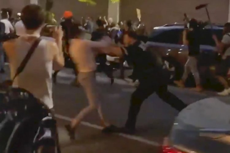 In this photo taken from video, New York police officer Vincent D'Andraia pushes Dounya Zayer during a protest in Brooklyn on May 29. D'Andraia, who was caught on video shoving Zayer to the ground, was charged Tuesday with assault and other crimes in the confrontation.