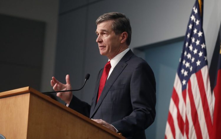 North Carolina Gov. Roy Cooper speaks during a briefing at the Emergency Operations Center in Raleigh, N.C., on Tuesday. President Trump announced the news via tweet, complaining that Cooper and other officials “refuse to guarantee that we can have use of the Spectrum Arena” and were not “allowing us to occupy the arena as originally anticipated and promised.” 