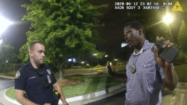 This screen grab taken from body camera video shows Rayshard Brooks speaking with Officer Garrett Rolfe in the parking lot of a Wendy's restaurant, late Friday in Atlanta. Rolfe has been fired following the fatal shooting of Brooks, and a second officer has been placed on administrative duty. 