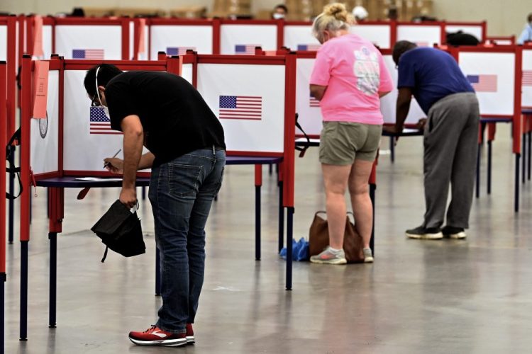 Voters fill out their ballots at the Kentucky Exposition Center in Louisville, Ky., on Tuesday. In an attempt to prevent the spread of the coronavirus, neighborhood precincts were closed and voters that didn't cast mail in ballots were directed to one central polling location. 