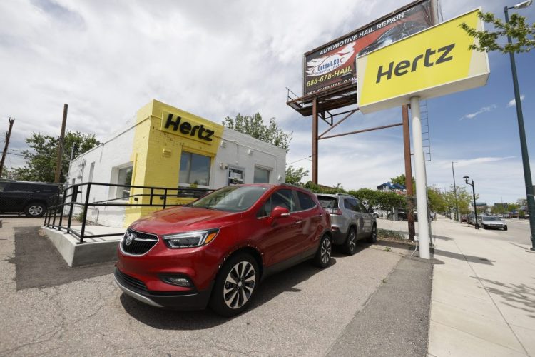 This 2020, photo shows rental vehicles parked outside a closed Hertz car rental office in south Denver, Colo.

