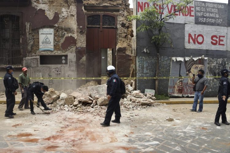 A policeman removes rubble from a building damaged by an earthquake in Oaxaca, Mexico, on Tuesday. 