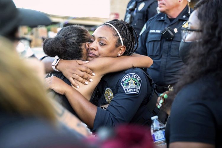 Police officer Alexandra Parker hugs a protester June 4 at the Austin Police Department headquarters during a Black Lives Matter rally in Austin.