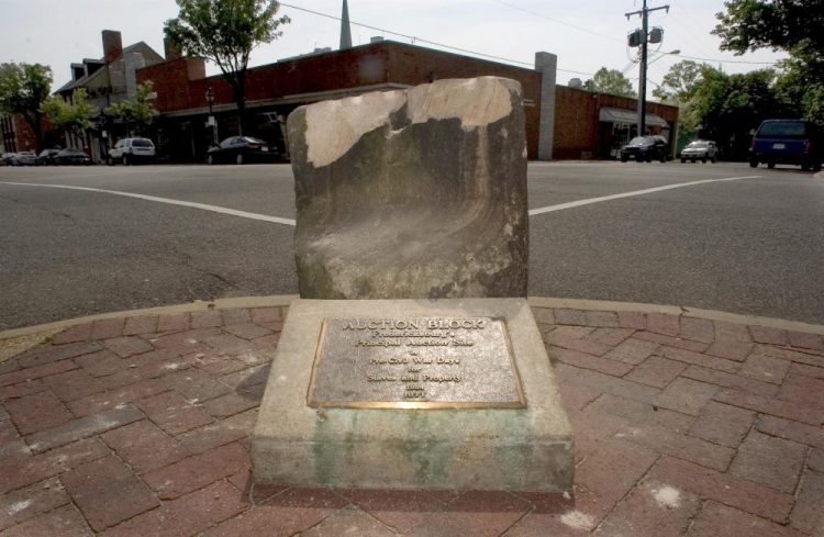 This 2005 photo shows the historic pre-civil war auction block for slaves and property at the corner of Charles and William Streets in downtown Fredericksburg, Va. The 800-pound stone was pulled from the ground early Friday, after its removal was delayed for months by lawsuits and the coronavirus pandemic.