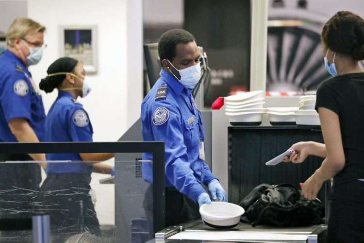 TSA officers wear protective masks at a security screening area at Seattle-Tacoma International Airport  in SeaTac, Washington, in May. 