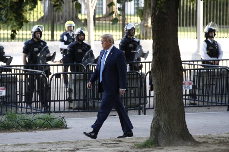President Trump walks in Lafayette Park to visit outside St. John's Church across from the White House on Monday. Part of the church was set on fire during protests on Sunday night. 