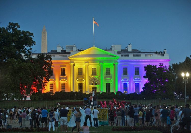 People gather in Lafayette Park on June 26, 2015, to see the White House illuminated with rainbow colors in commemoration of the Supreme Court's ruling to legalize same-sex marriage. On Friday, the Trump administration finalized a regulation that overturns Obama-era protections for transgender people against sex discrimination in health care.