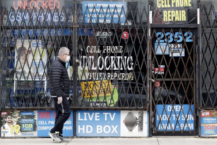 A man walks by a closed store in Chicago. Layoffs are declining and hiring is slowly picking up, yet it's not clear where the job market goes next. Federal Reserve Chairman Jerome Powell and other economists have warned that a second coronavirus outbreak would lead many more consumers to stay home, thereby dealing another blow to restaurants, bars and retailers.