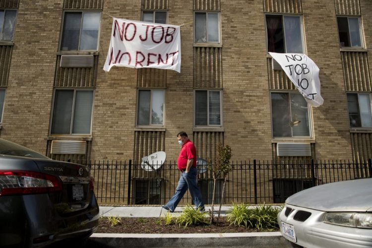 Signs that read "No Job No Rent" hang from the windows of an apartment building in Washington. Once the federal moratorium ends on Friday, landlords can give their delinquent tenants 30 days' notice and then begin filing eviction paperwork in late August. 