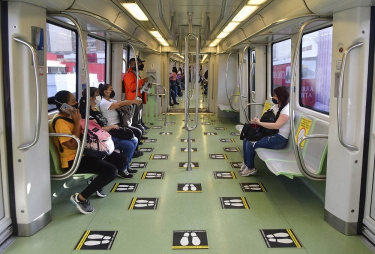 Commuters travel on a train marked with social distancing graphic cues, amid the new coronavirus pandemic, June 8 in Medellin, Colombia. The metropolis recently went five weeks without a single COVID-19 death.