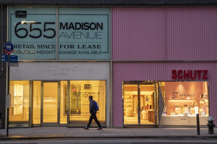 A pedestrian walks past a storefront for rent on Madison Avenue, in New York City. 