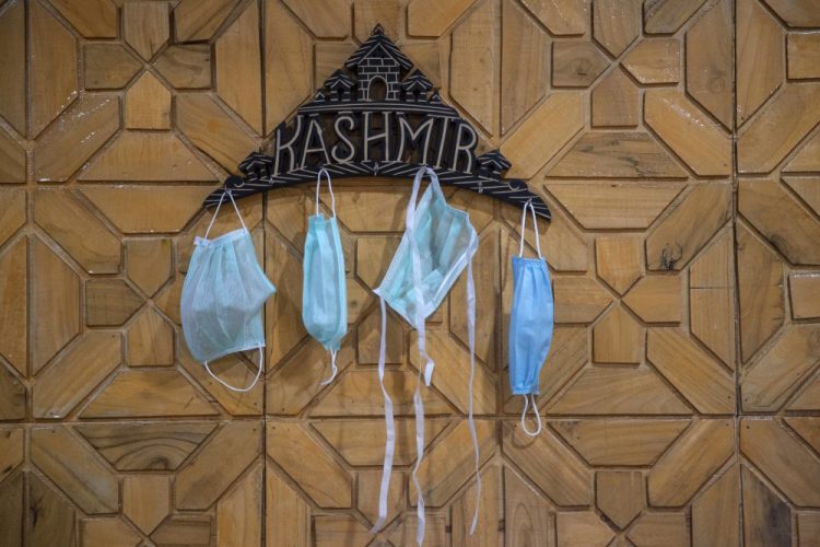 Surgical masks hang on a key holder inside a residential house Saturday in Srinagar, India.