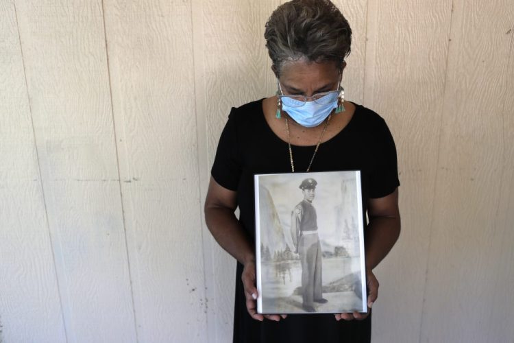 Belvin Jefferson White holds a portrait of her father, Saymon Jefferson, on May 18 at Saymon's home in Baton Rouge, La. Belvin recently lost both her father and her uncle, Willie Lee Jefferson, to COVID-19. 