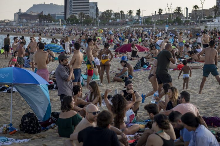 People enjoy the beach Sunday in Barcelona, Spain. Spain ended a national state of emergency after three months of lockdown, allowing its 47 million residents to freely travel around the country for the first time since March 14. The country also dropped a 14-day quarantine for visitors from Britain and the 26 European countries that allow visa-free travel.
