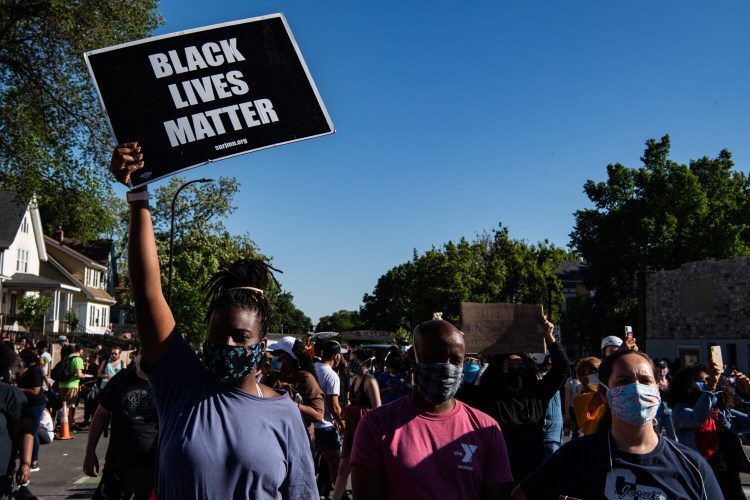 A protester lifts a Black Lives Matter sign at a memorial site for George Floyd in Minneapolis on May 30.