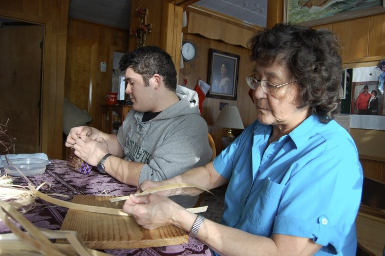 Molly Neptune Parker of Princeton makes a basket with her grandson Geo Neptune in this 2012 file photo. Neptune Parker, a winner of a National Heritage Fellowship from the National Endowment for the Arts, has died.