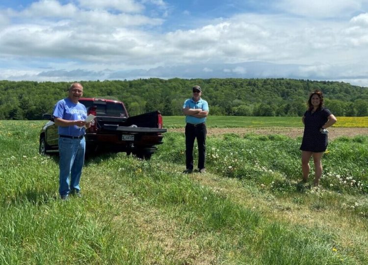 Planning Board members Bruce White, left, Samantha Burdick, right, and developer Kevin Violette are seen at the site of a proposed solar farm off County Road in Waterville. 