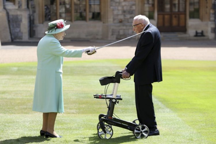 Capt. Sir Thomas Moore receives his knighthood from Britain's Queen Elizabeth during a ceremony at Windsor Castle in Windsor, England, on Friday. Sir Tom raised about $40 million for health service charities by walking laps of his Bedfordshire garden. 