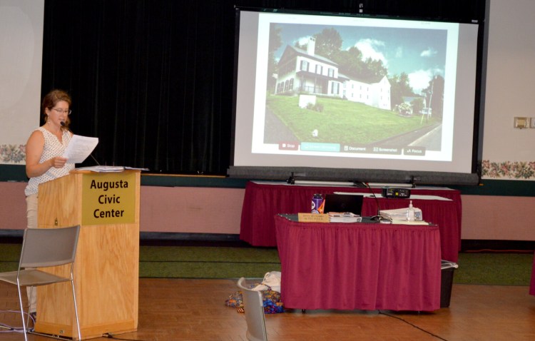 Deputy City Planner Betsy Poulin introduces the Kennebec Historical Society building expansion project with a rendering of the final product in the background.