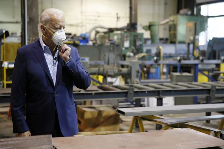 Democratic presidential candidate and former Vice President Joe Biden adjusts his mask Thursday during a tour of McGregor Industries, a metal fabricating facility in Dunmore, Pa. 