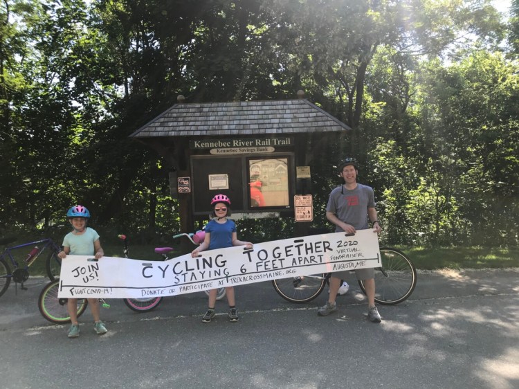 Eva McKenna, 9, left, Kelsey Glynn, 8 and her father, Greg Glynn of Augusta, take a photo together during a ride on the Kennebec River Rail Trail on June 20.