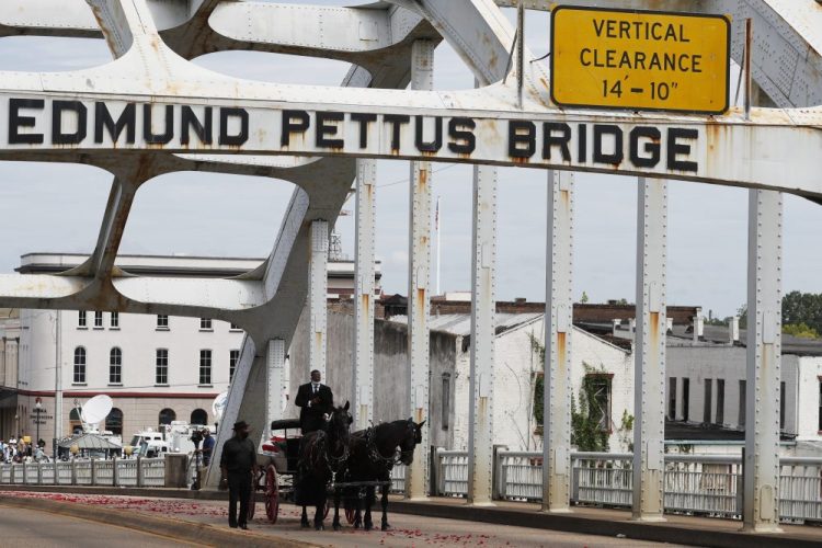 The casket of Rep. John Lewis moves over the Edmund Pettus Bridge by horse drawn carriage during a memorial service for Lewis on Sunday in Selma, Ala. Lewis, who carried the struggle against racial discrimination from Southern battlegrounds of the 1960s to the halls of Congress, died Friday, July 17, 2020. 