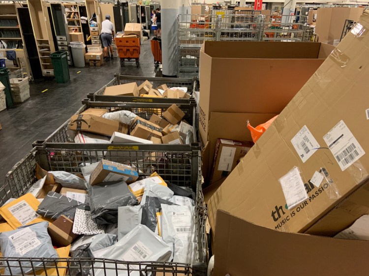 Mail sits in “shark cages” in the Portland post office because it was not delivered, according to letter carriers. While the bins contain a mix of parcels, including some Amazon parcels, carriers say they have been told to make Amazon deliveries the priority over first class mail.  