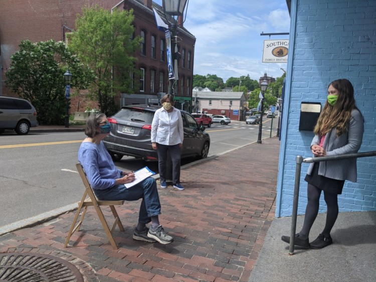 From left, Barbara Vickery, landowner, Carrie Kinne, Kennebec Estuary Land Trust executive director, and Jenny Burch, attorney, have a street side, socially-distant meeting in Bath to complete the land trust’s first land protection project in Richmond.