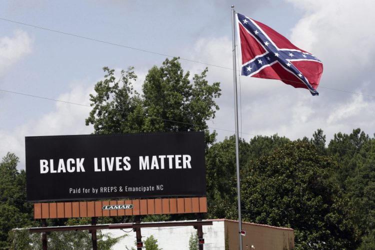A Black Lives Matter billboard is seen next to a Confederate flag in Pittsboro, N.C., Thursday, July 16, 2020. A group in North Carolina erected the billboard to counter the flag that stands along the road. 