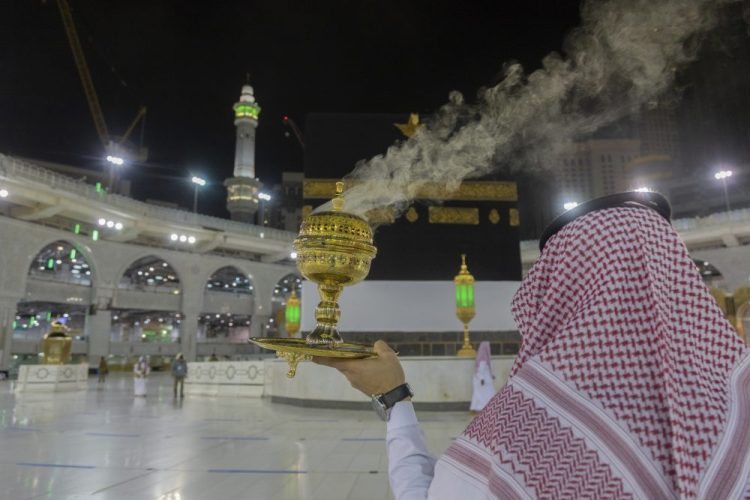 A man burns incense as the area around the Kaaba, the square structure in the Great Mosque, toward which believers turn when praying, is prepared for pilgrims, in Mecca, Saudi Arabia, late Sunday. 