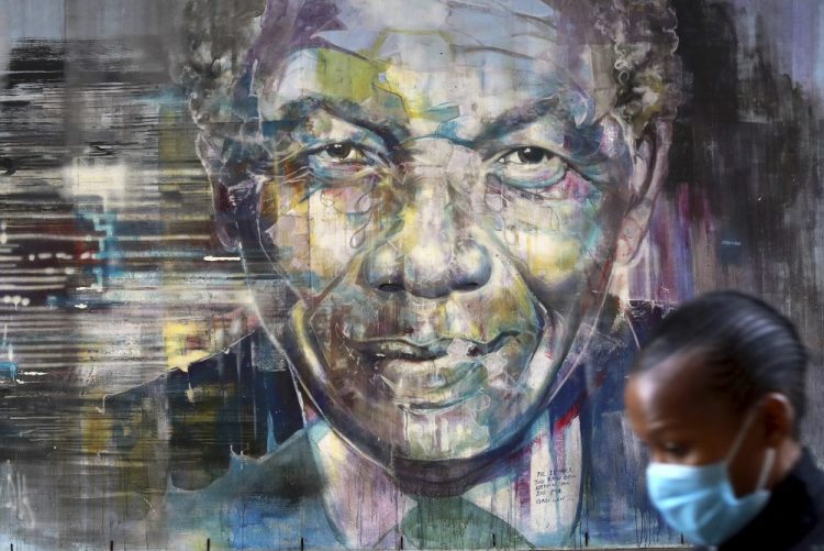 A woman walks past a mural of former President Nelson Mandela in Cape Town, South Africa, on Saturday, as the country celebrates International Mandela Day. Mandela's fight for freedom and human rights makes him the most influential person among Africa's youth, according to a survey conducted across the continent.   