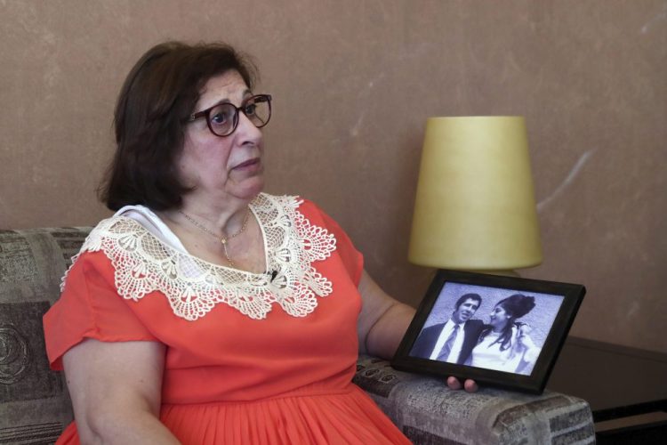 Laure Ghosn, whose husband Charbel Zogheib has been missing for the past 37 years, speaks as she holds their wedding portrait during an interview at her home in Sarba, north of Beirut, Lebanon.