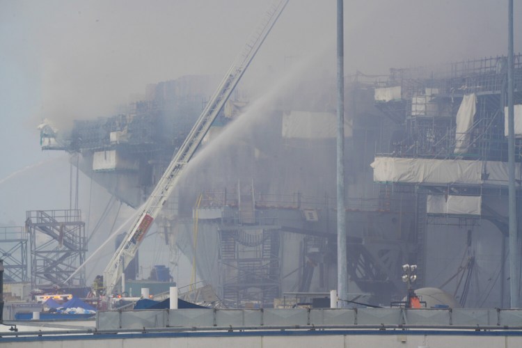 A fire continues to burn more than 24 hours later, aboard Bonhomme Richard at San Diego Naval Base on Monday. 