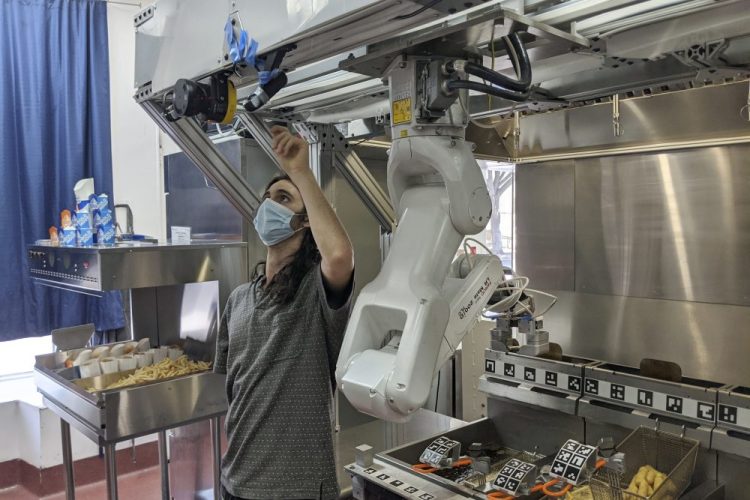 A technician makes an adjustment to a robot at Miso Robotics' White Castle test kitchen in Pasadena, Calif. The robot, dubbed Flippy, currently costs $30,000, with a $1,500 monthly service fee.  