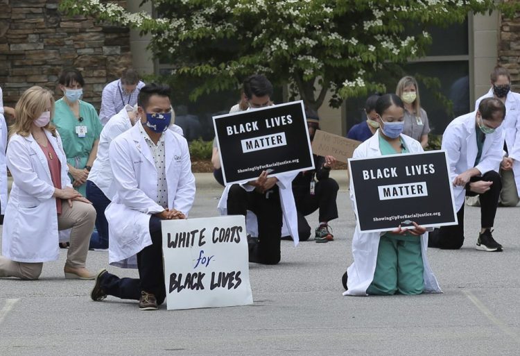 Physicians, residents and staff from the a facility in Asheville, N.C., take a knee June 5 to show support for renewed calls for racial justice after the police killing of George Floyd. 