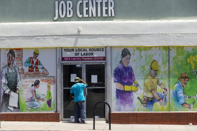 A person looks inside the closed doors of the Pasadena Community Job Center May 7 in Pasadena, Calif. 