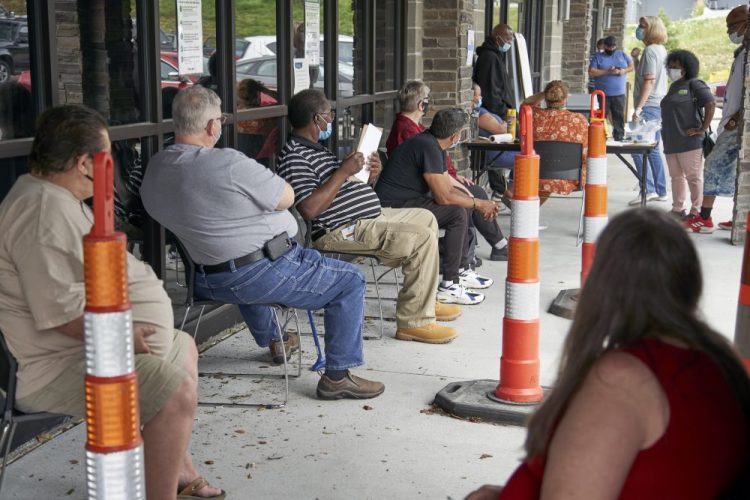 Job seekers wait to be called into the Heartland Workforce Solutions office on July 15 in Omaha, Neb. A Republican proposal to slash the $600 weekly benefit boost for those left jobless because of the coronavirus shutdown could result in weeks or even months of delayed payments in some states.