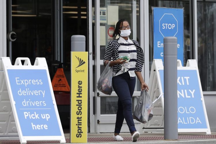 A shopper wears face masks as she leaves a Walmart retail store in Vernon Hills, Ill., Thursday, July 30. 