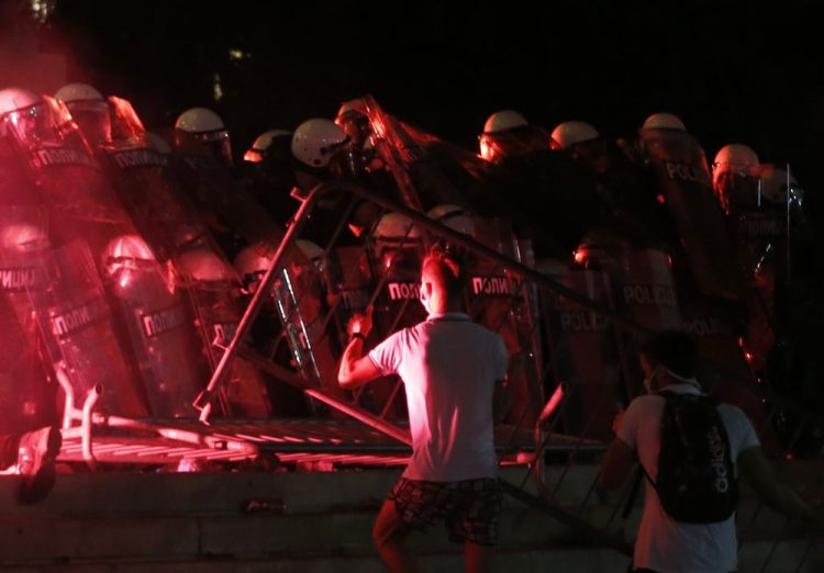 Protesters clash with riot police on the steps of the Serbian parliament Friday during a protest in Belgrade, Serbia.