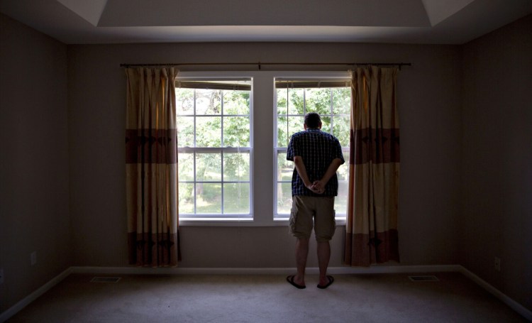 A prospective home buyer looks out the master bedroom window at a house for sale in Dunlap, Ill. U.S. home sales rebounded sharply in June after months of declines during the pandemic.
