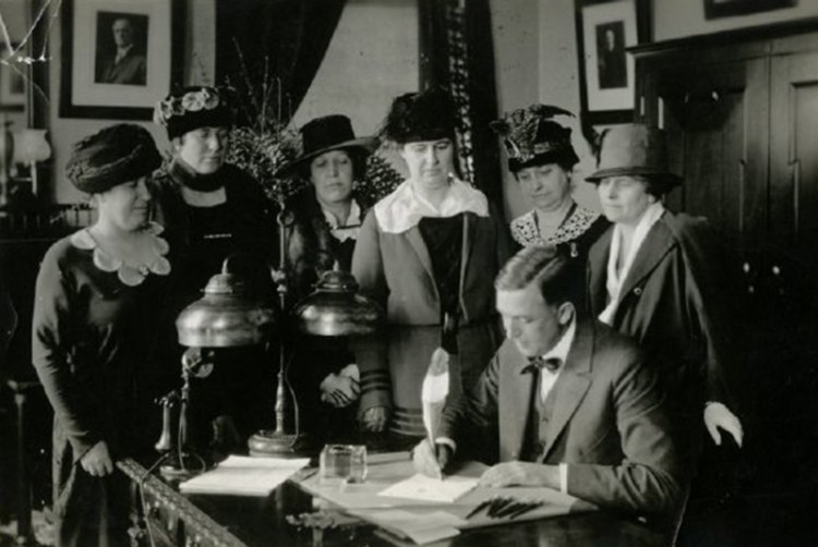 Gov. Carl Milliken of Maine signs Maine's ratification of the Federal Suffrage Amendment with the purple, gold, and white National Woman's Party pen on November 5th, 1919. The pen was designed for the ratification and was sent from state to state.

